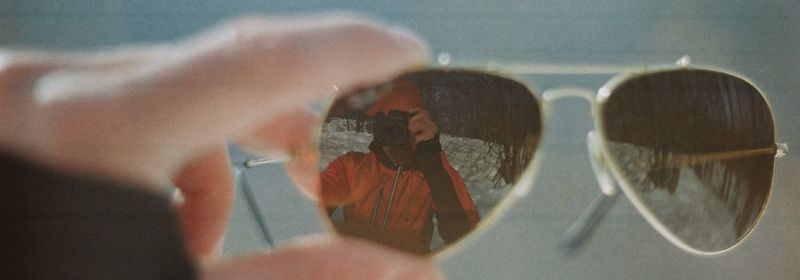 Close-up of hands holding glass with reflection