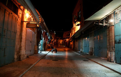 Illuminated alley amidst buildings in city at night