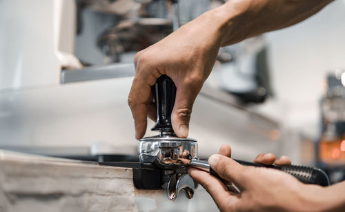 Close-up of hand operating machine in factory