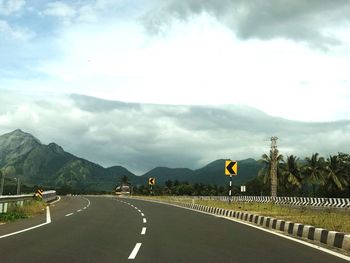 Road by mountains against sky