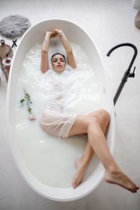 High angle view of woman lying in bathtub