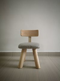 Close-up of empty seats on table against wall