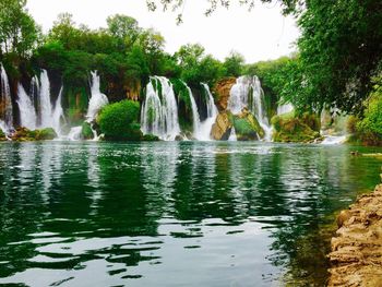 Scenic view of waterfall against sky