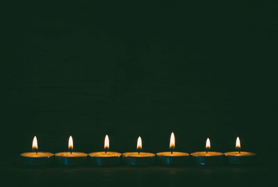 Close-up of illuminated candles in temple