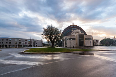 Building by road against sky in city