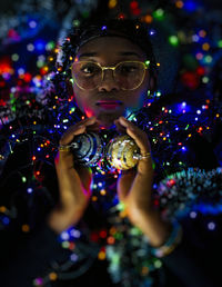 Portrait of woman holding christmas decorations balls