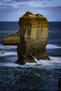 Rock formation in sea against sky