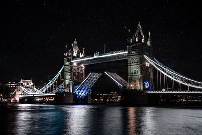 London tower bridge lifting up at night.