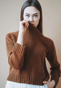 Portrait of woman standing against wall