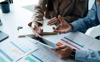 Midsection of business people working on table