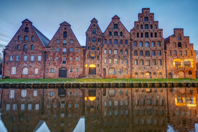 The old salzspeicher reflecting in the trave river at dawn, seen in luebeck, germany