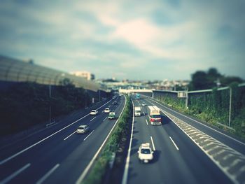 Vehicles on highway against sky in city
