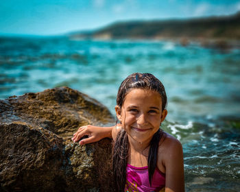 Portrait of a smiling young woman on rock