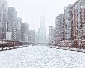 Modern buildings in city against sky during winter