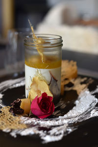 Close-up of rose in glass on table