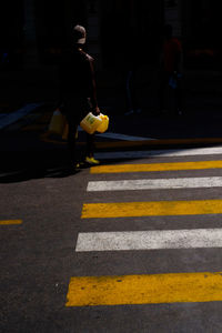 Man crossing road in sunny day