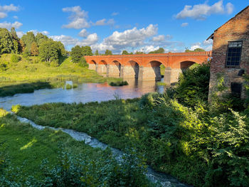 Arch bridge over river against sky