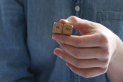 Midsection of women holding toy blocks with text