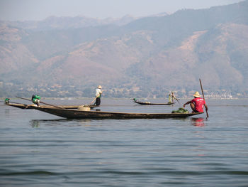 Fishermen rowing boats on river