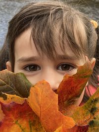 Close-up portrait of girl with autumn leaves