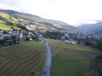 Scenic view of field by buildings against sky