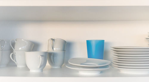 Cup with saucer and plates on shelf