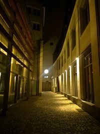 Empty walkway in city at night