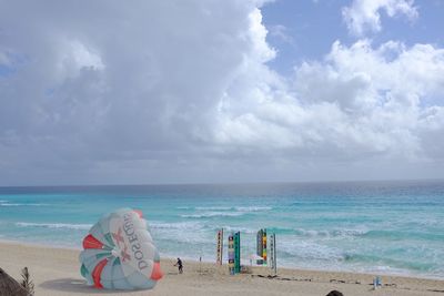 Scenic view of beach against cloudy sky