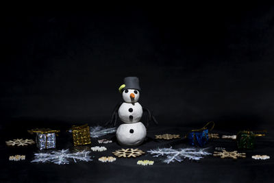 Close-up of figurine on table against black background