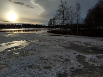 Scenic view of frozen river against sky during sunset