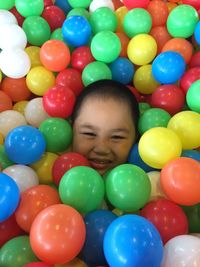 Portrait of smiling boy with multi colored balloons