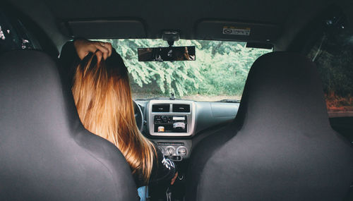 Rear view of woman sitting in car