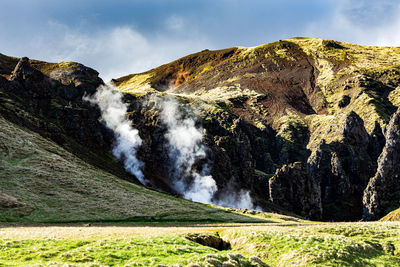 Scenic view of waterfall against sky