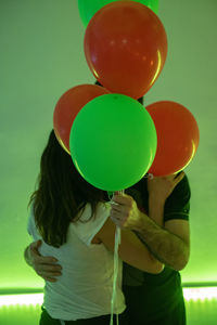 Rear view of woman holding colorful balloons