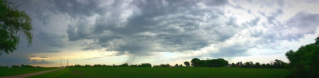 Scenic view of grassy field against cloudy sky