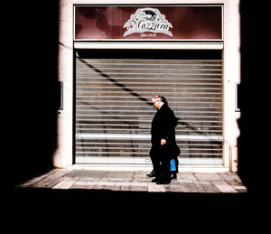 Full length of man standing against wall