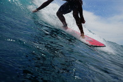 Low section of man splashing water in sea