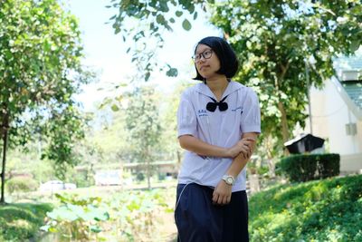 Girl wearing in-ear headphones while standing outdoors