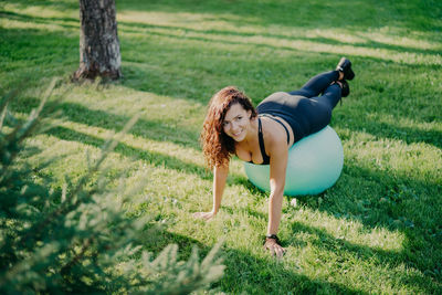 High angle view of woman exercising on fitness ball in park