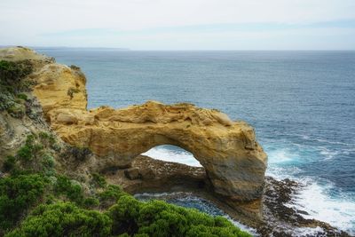 Rock formation in sea against sky