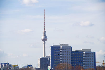 Distant view of fernsehturm in city against sky