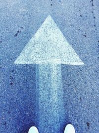 Low section of man walking on road