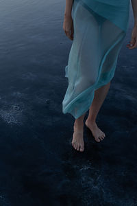 Low section of woman standing on beach