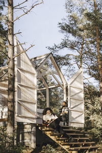 Couple sitting on steps of cottage in forest