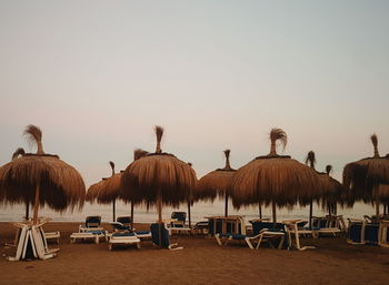 Panoramic view of chairs on beach against clear sky