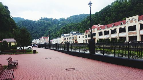 Buildings by river in city against sky