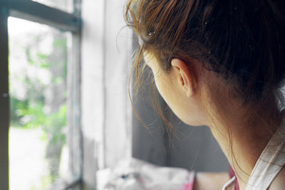 Close-up of young woman painting wall