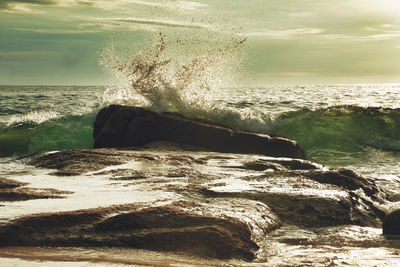 Scenic view of rocks in sea against sky