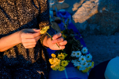 Close-up of woman holding flower outdoors