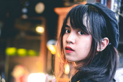 Close-up of woman in city at night